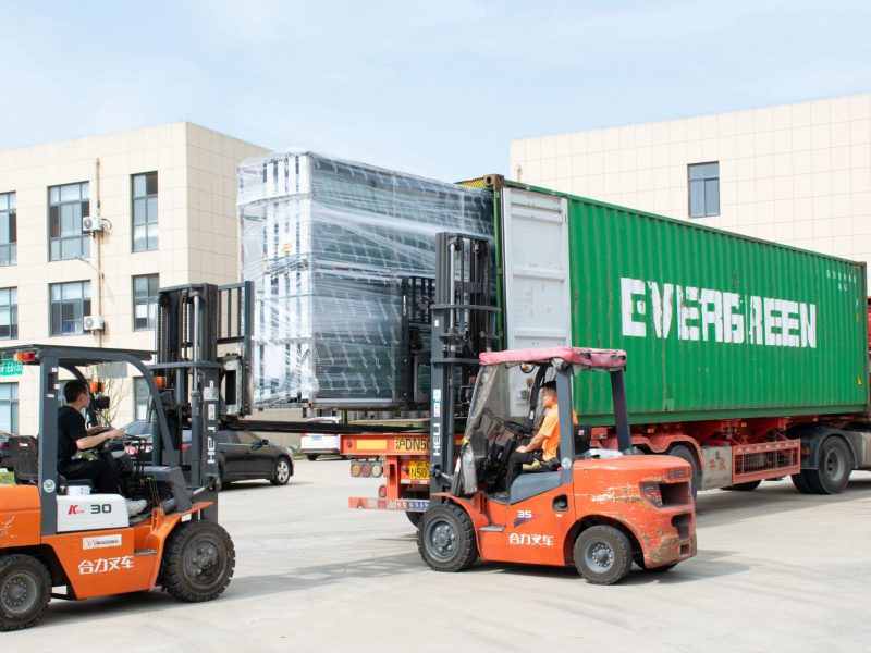 YY WINDOWS factory worker using a forklift to load products into a shipping container